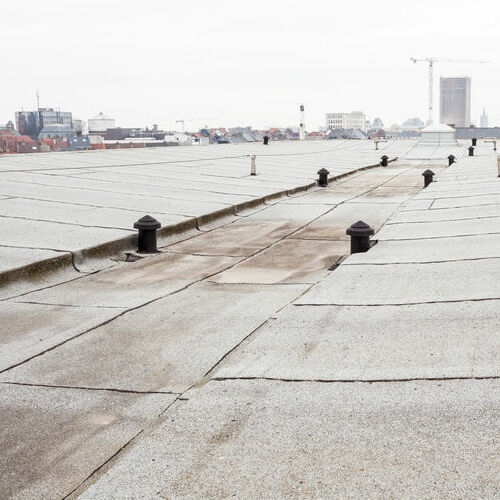 Commercial flat roof with cityscape in the background.