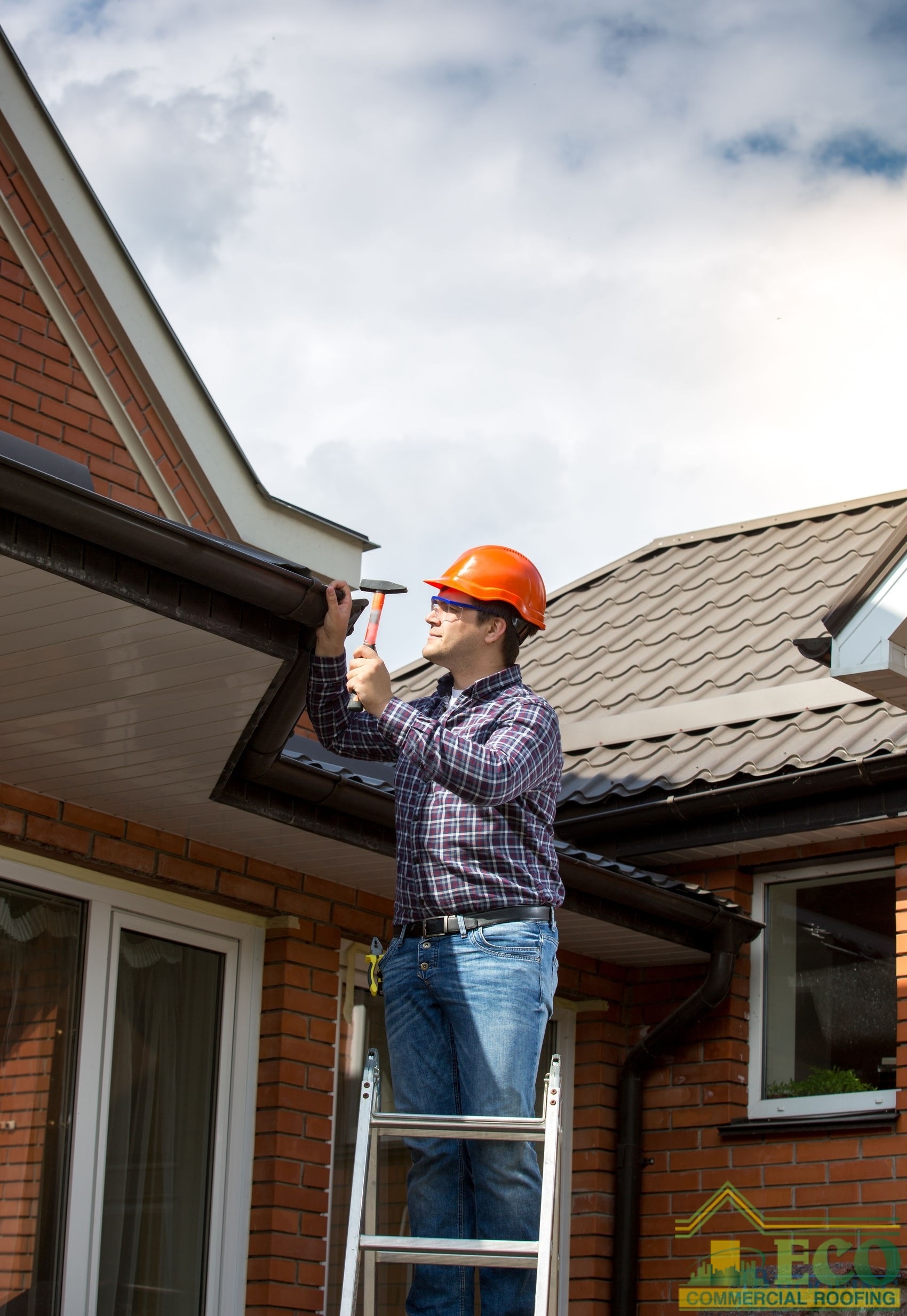 Man with Orange Hard Hat on Ladder Inspecting Roof