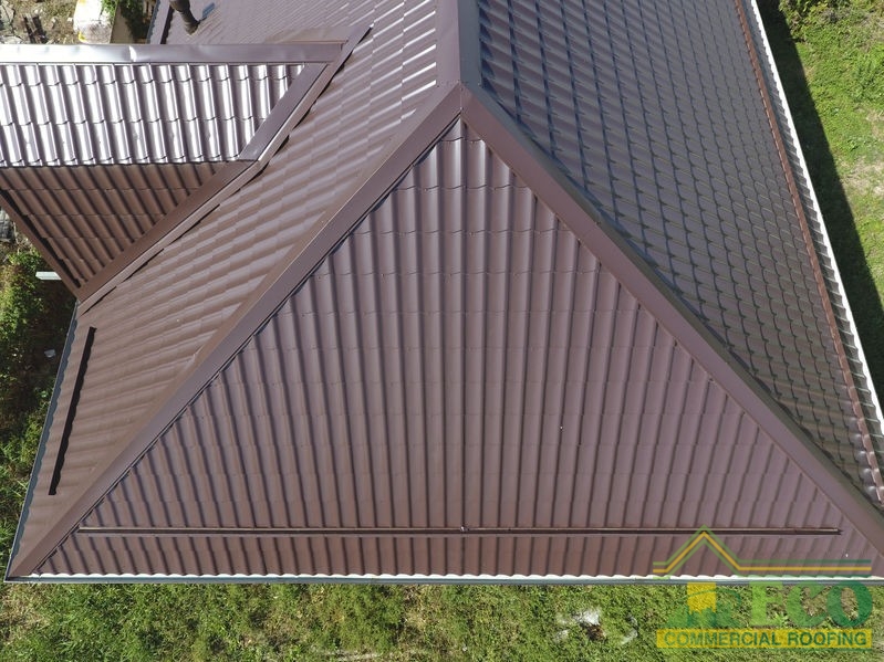 The roof of corrugated sheet. Roofing of metal profile wavy shape. A view from above on the roof of the house.